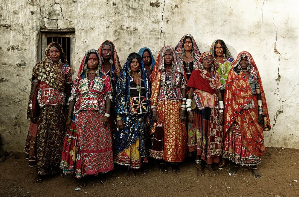 A group of Banjara women standing together in traditional mirror-work dress and silver jewellery